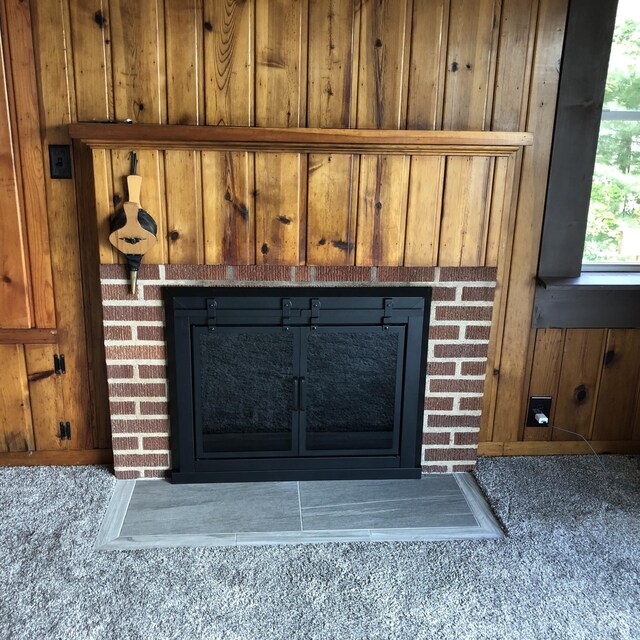 589 E Sidney Rd, Stanton, MI 48888 - detailed view of a brick fireplace, wood walls, and carpet flooring