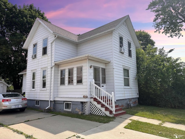 view of front of house with cooling unit and a yard