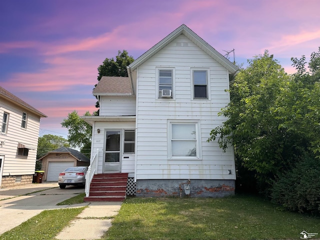 view of front facade featuring a garage, cooling unit, an outdoor structure, and a lawn