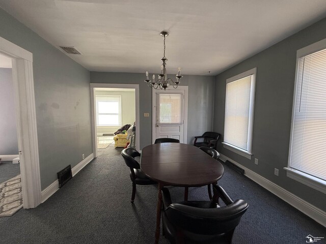 carpeted dining area featuring a notable chandelier