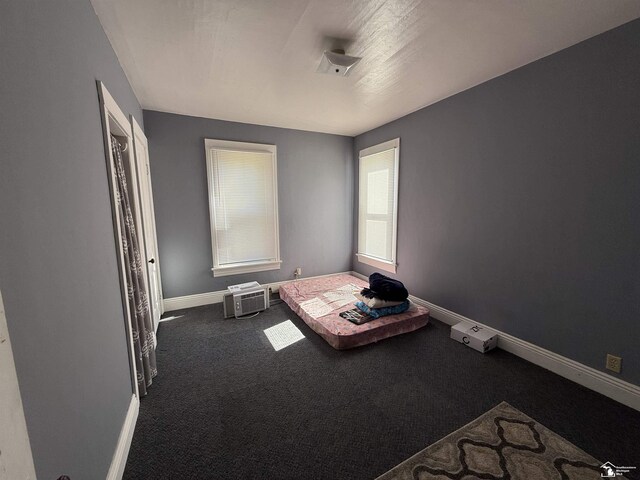 unfurnished bedroom with dark carpet