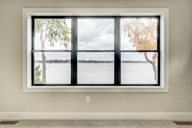 interior space featuring carpet flooring and a water view