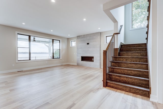 unfurnished living room featuring a fireplace, plenty of natural light, and light wood-type flooring