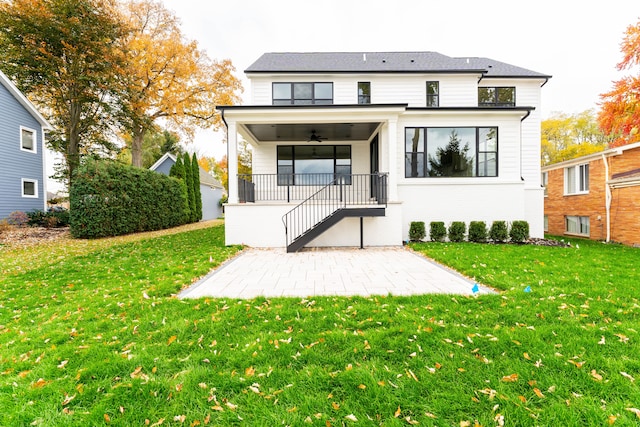 rear view of property with a lawn, ceiling fan, and a patio