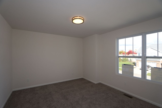 carpeted spare room featuring plenty of natural light