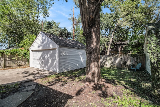 view of yard featuring a garage and an outbuilding