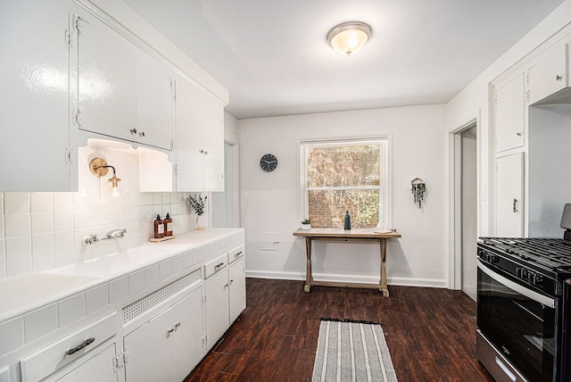 kitchen with decorative backsplash, stainless steel range with gas cooktop, dark hardwood / wood-style flooring, and white cabinets