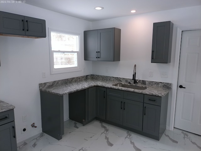 kitchen featuring sink, gray cabinets, electric panel, and light stone countertops