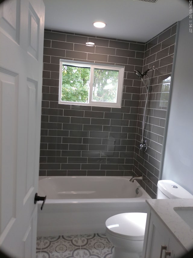 full bathroom with vanity, toilet, tiled shower / bath combo, and tile patterned flooring