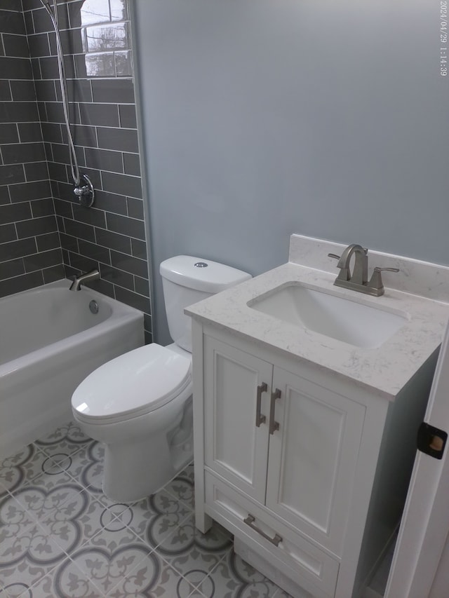 full bathroom with tile patterned flooring, vanity, tiled shower / bath combo, and toilet