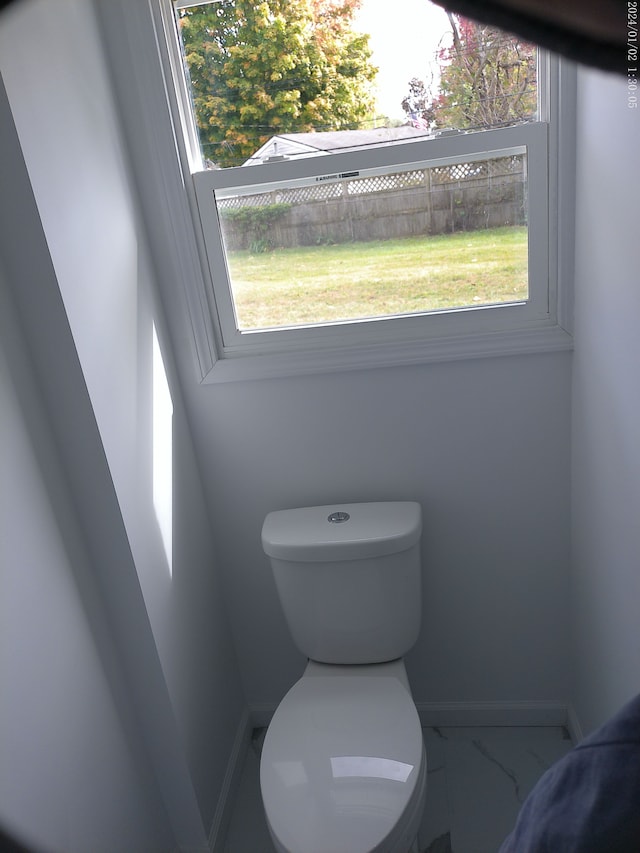 bathroom with plenty of natural light and toilet