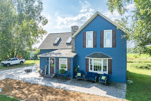 view of front of property featuring a front yard, an outdoor living space, and a patio area