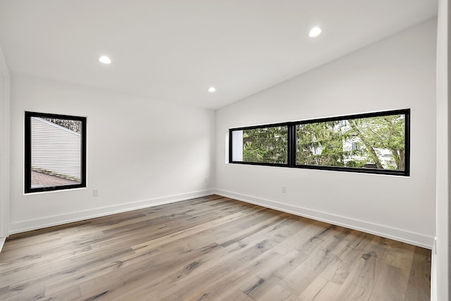 spare room with light wood-style flooring, baseboards, vaulted ceiling, and recessed lighting