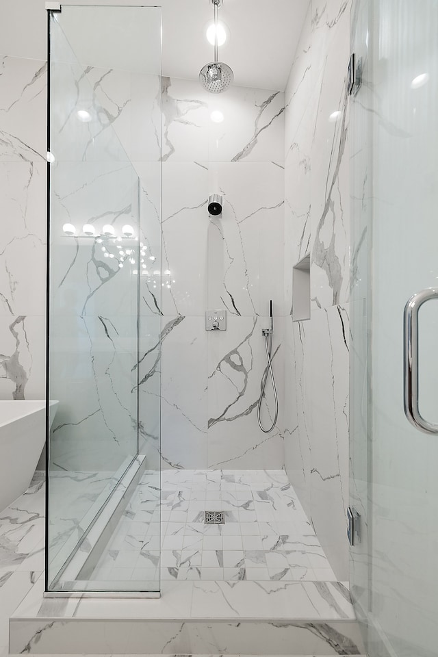 bathroom with marble finish floor, a marble finish shower, and stone wall