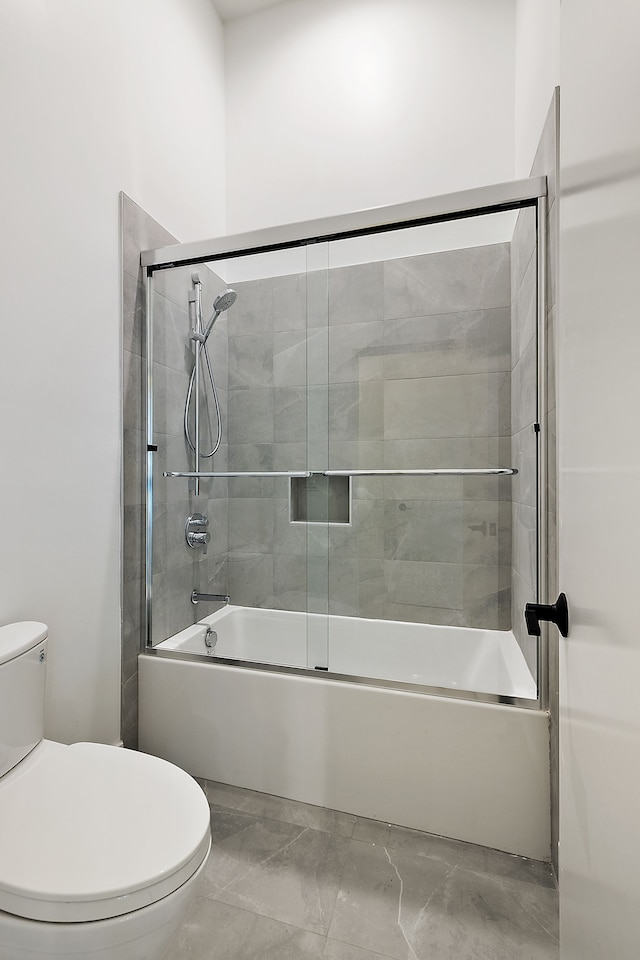 full bath featuring combined bath / shower with glass door and toilet