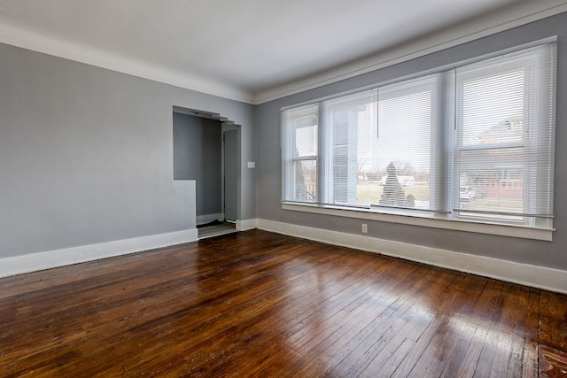 spare room featuring dark hardwood / wood-style floors and crown molding