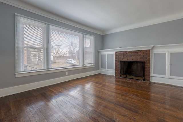 unfurnished living room with plenty of natural light, dark hardwood / wood-style flooring, a fireplace, and crown molding