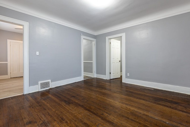 spare room with crown molding and dark hardwood / wood-style floors