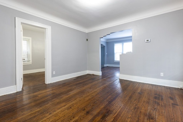 empty room with dark hardwood / wood-style floors and ornamental molding