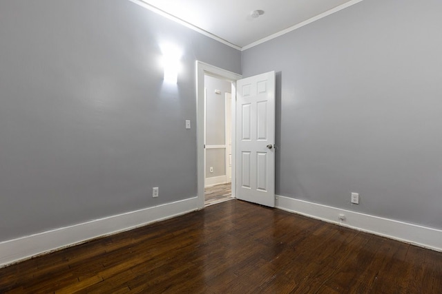 empty room featuring dark hardwood / wood-style flooring and ornamental molding