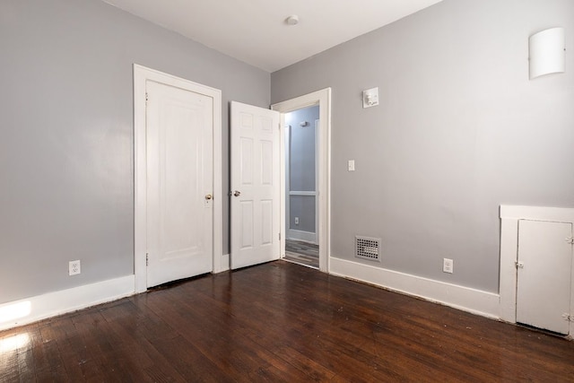 unfurnished bedroom with dark wood-type flooring