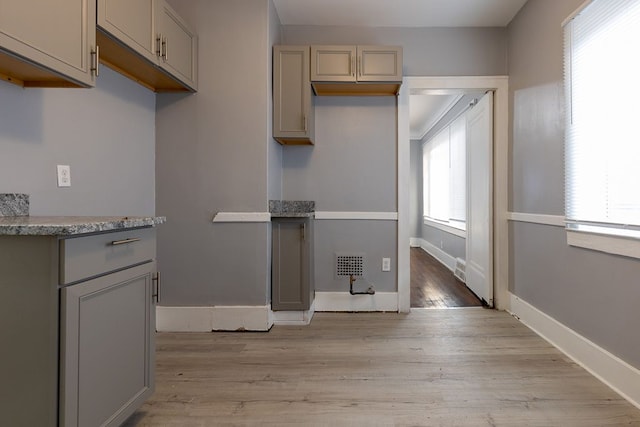 kitchen with gray cabinets and light hardwood / wood-style flooring