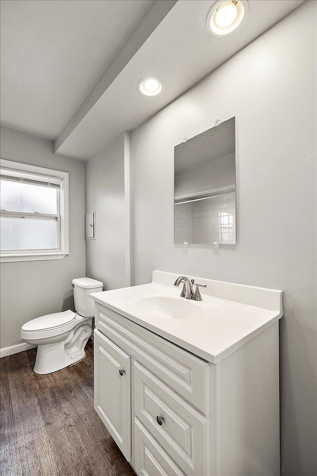 bathroom with hardwood / wood-style floors, vanity, and toilet