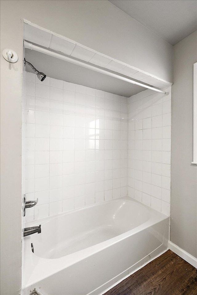 bathroom with wood-type flooring and tiled shower / bath