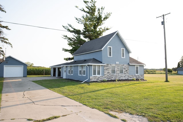 view of front facade with a garage, an outbuilding, and a front lawn