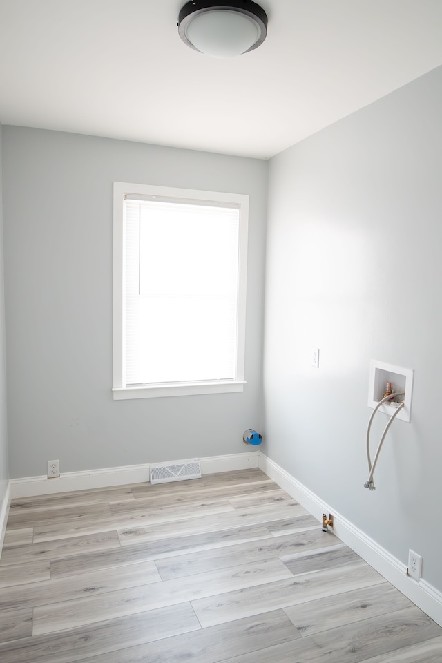 clothes washing area with gas dryer hookup, washer hookup, and light wood-type flooring