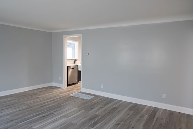 spare room featuring light hardwood / wood-style flooring and ornamental molding