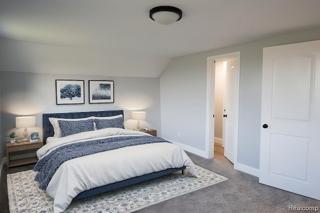 bedroom with dark carpet and lofted ceiling