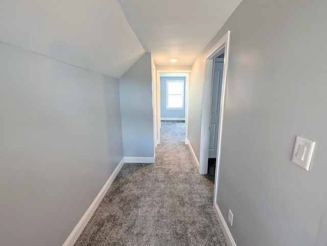 hallway with carpet flooring and vaulted ceiling