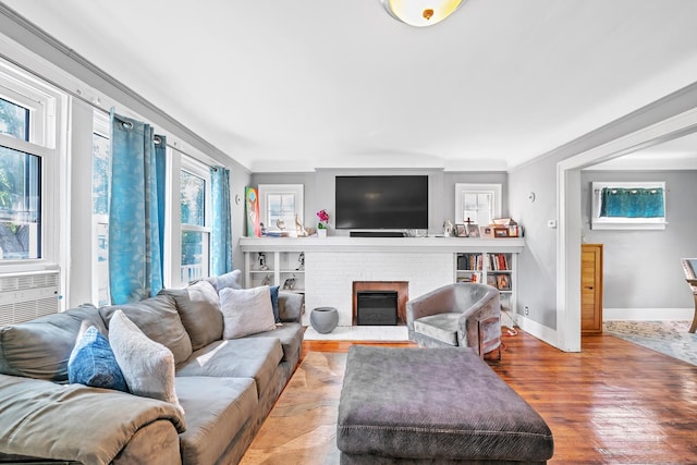 living room featuring a fireplace, light hardwood / wood-style floors, and crown molding