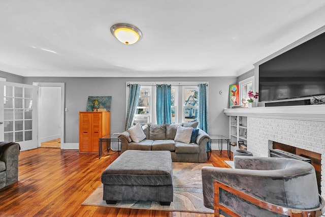 living room featuring a fireplace, wood-type flooring, and french doors