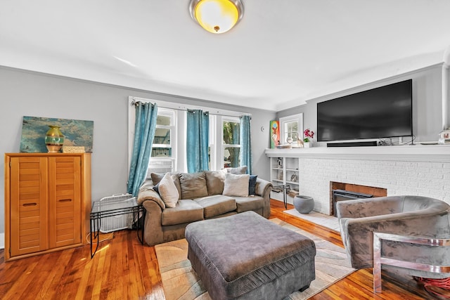 living room featuring a fireplace, light hardwood / wood-style flooring, and ornamental molding