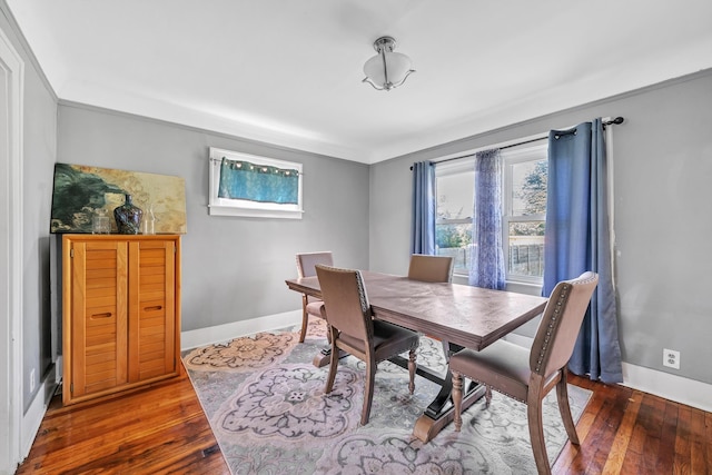 dining space featuring wood-type flooring and ornamental molding