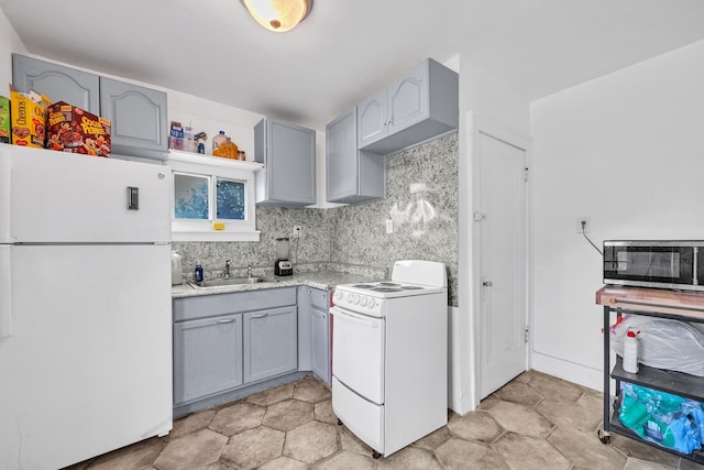 kitchen with white appliances, gray cabinets, backsplash, and sink