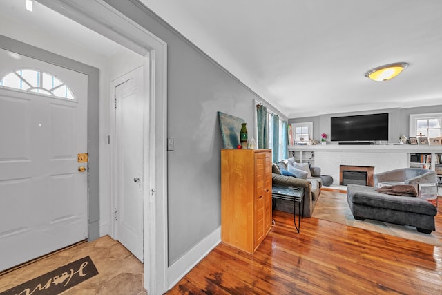 foyer with wood-type flooring and a fireplace