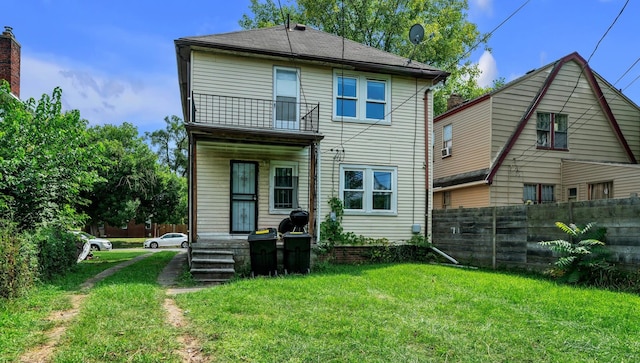 back of house with a yard and a balcony