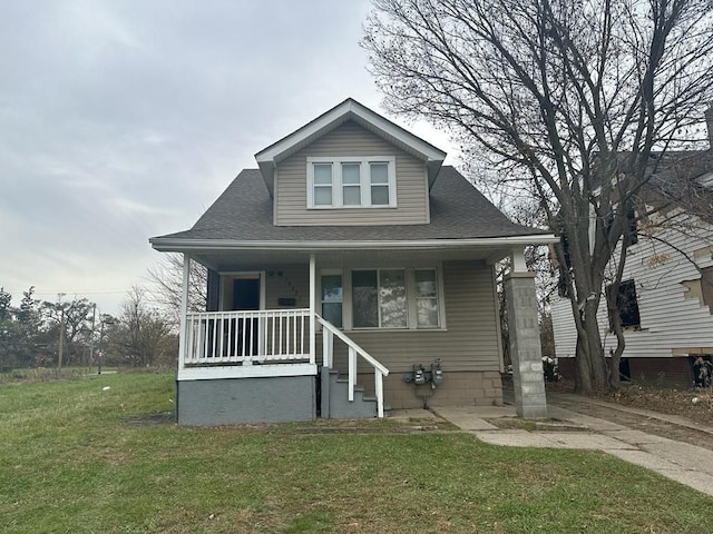 bungalow-style home with roof with shingles, a porch, and a front yard