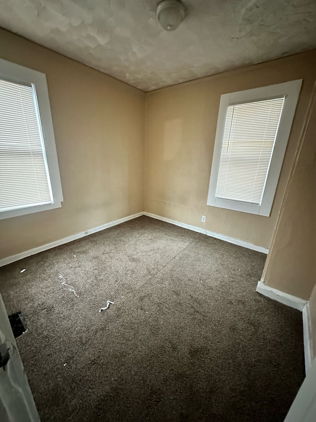 empty room with carpet and baseboards