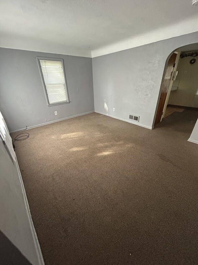 928 Mann Ave, Flint, MI 48503 - carpeted empty room featuring arched walkways and baseboards