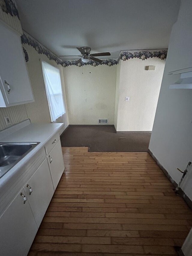 928 Mann Ave, Flint, MI 48503 - kitchen featuring white cabinetry, dark wood-style floors, ceiling fan, light countertops, and a sink