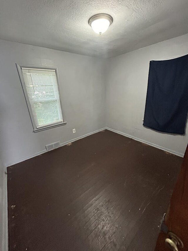 928 Mann Ave, Flint, MI 48503 - spare room featuring a textured ceiling and wood finished floors