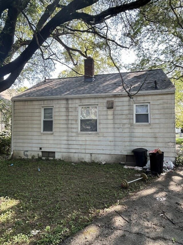 928 Mann Ave, Flint, MI 48503 - view of property exterior featuring a chimney and a shingled roof