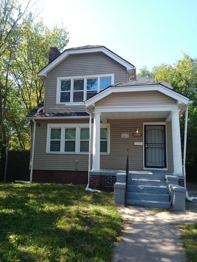 12293 Sorrento St, Detroit, MI 48227 - view of front of property featuring covered porch, a chimney, and a front yard