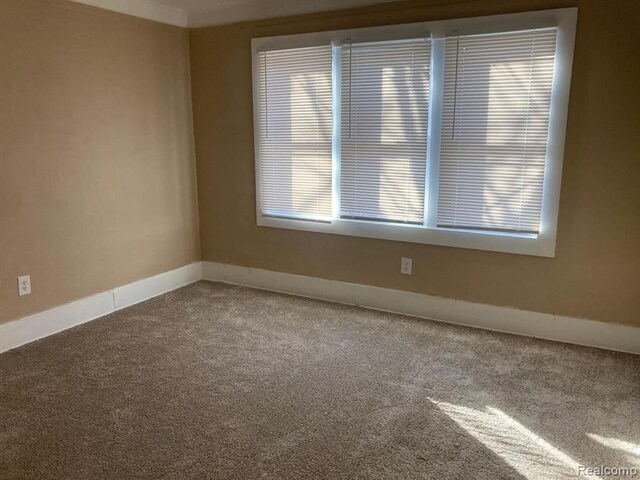 12293 Sorrento St, Detroit, MI 48227 - empty room with carpet flooring, baseboards, and plenty of natural light