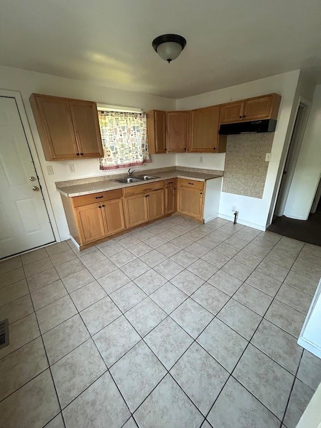 kitchen featuring light tile patterned floors and sink