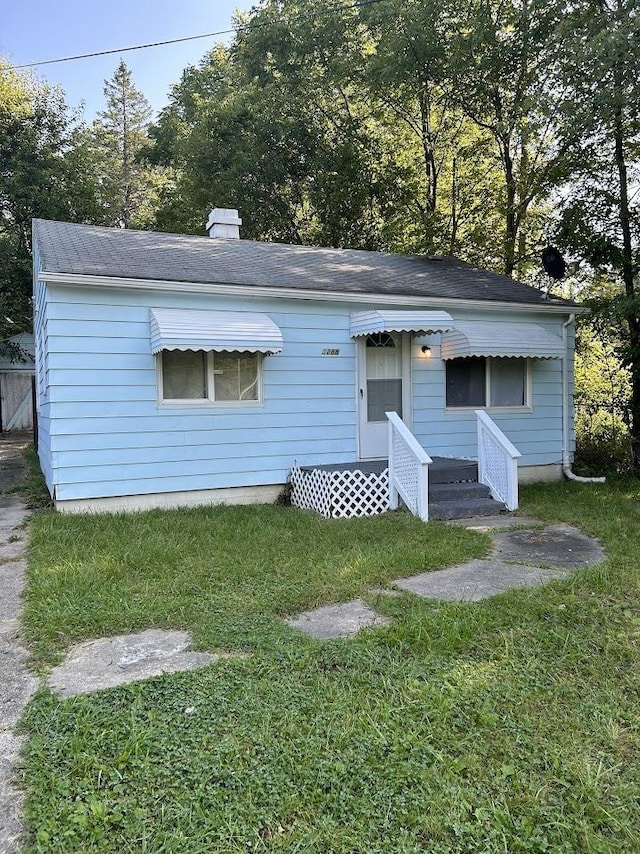 3288 Kissner Ave, Flint, MI 48504 - bungalow-style home with a front lawn, entry steps, a chimney, and a shingled roof